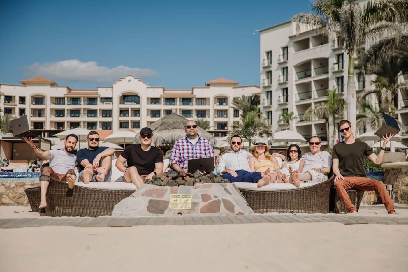 Christian and a group of business owners on the beach in Cabo, laptops in hand